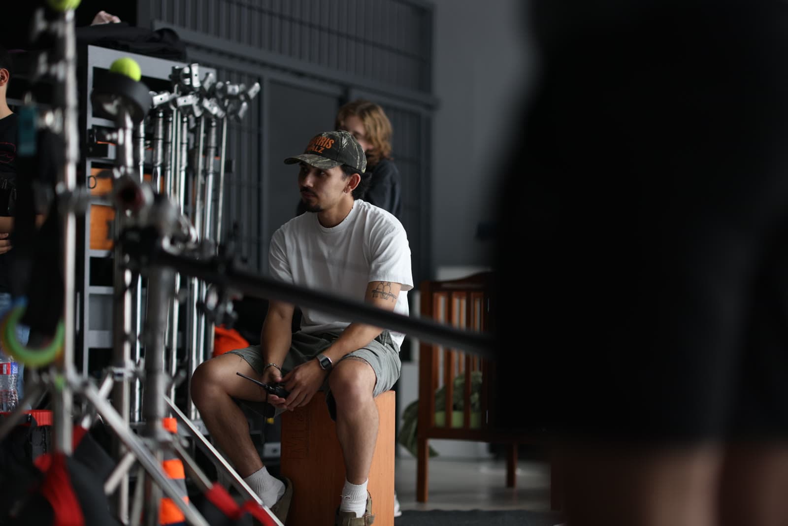 Crew members wait among grip stands between setups