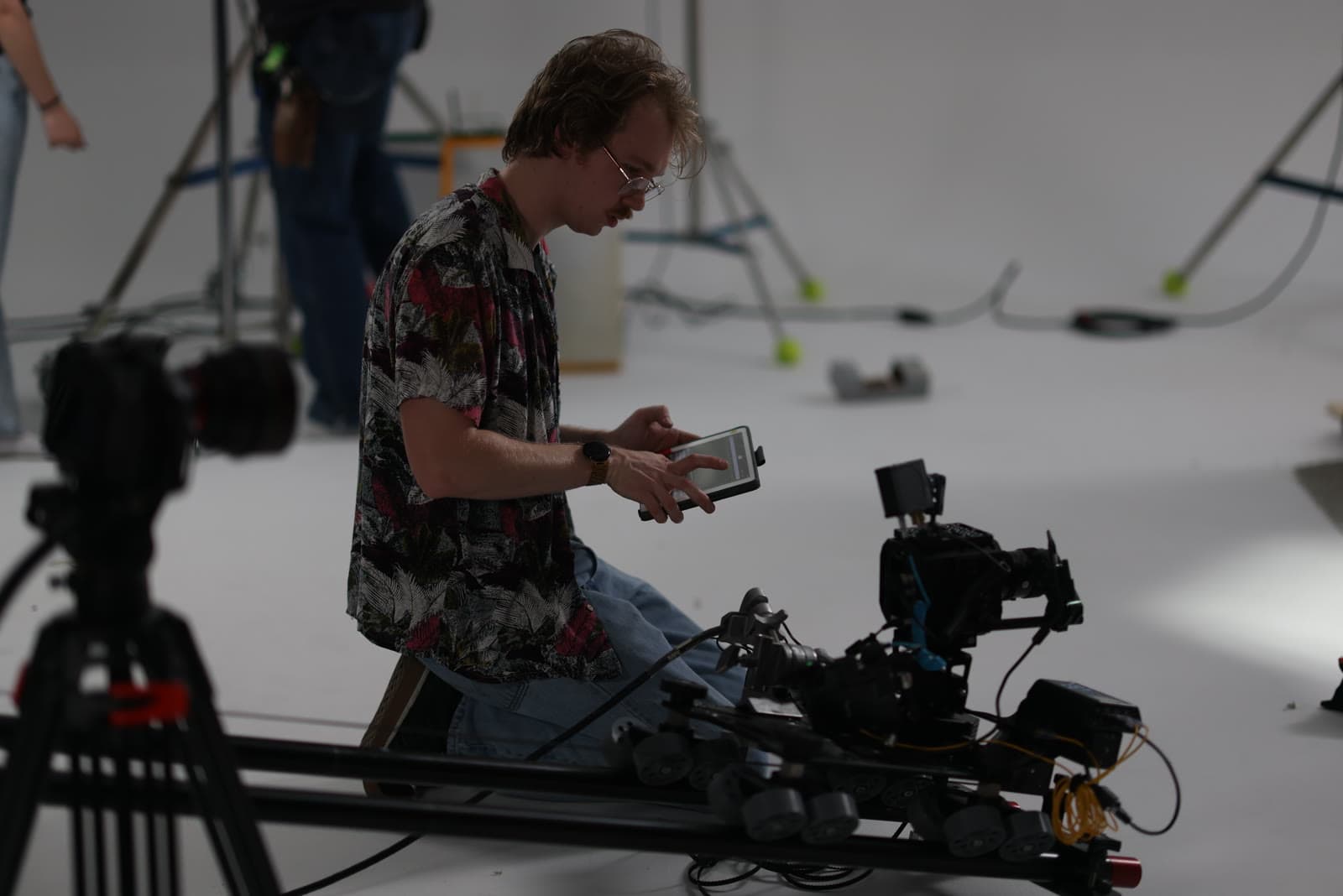A camera operator checks a shot on a slider in the studio